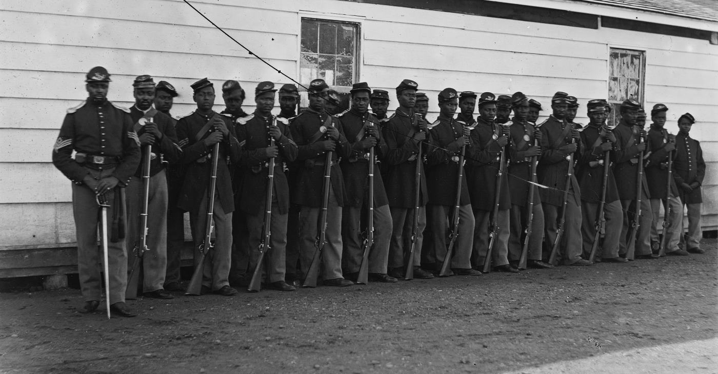 Četa E, 4. puk Afroameričkih trupa Unije fotografisana u Fort Lincolnu, 17. novembra 1865. godine. Ova jedinica bila je dio novoformiranih Afroameričkih trupa nakon Proklamacije o emancipaciji, predstavljajući značajan korak ka uvođenju Afroamerikanaca u vojne redove tokom Američkog građanskog rata.